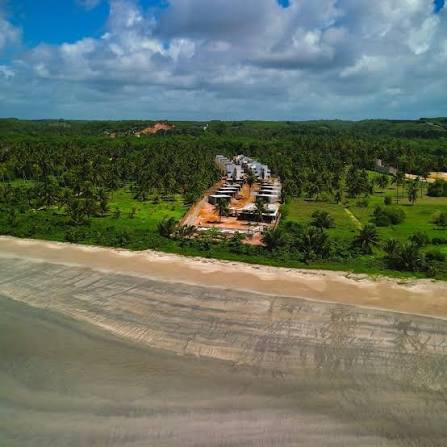 Obra do Hoti Patacho Residence em andamento, vista aérea entre coqueirais e a praia